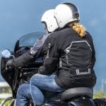Passenger on bike wearing the Helite Touring Black biker jacket, rear view